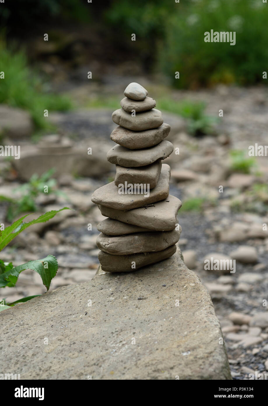 Stone balancing, stones balanced on top of one another on a large rock in burrs country park bury lancashire uk Stock Photo