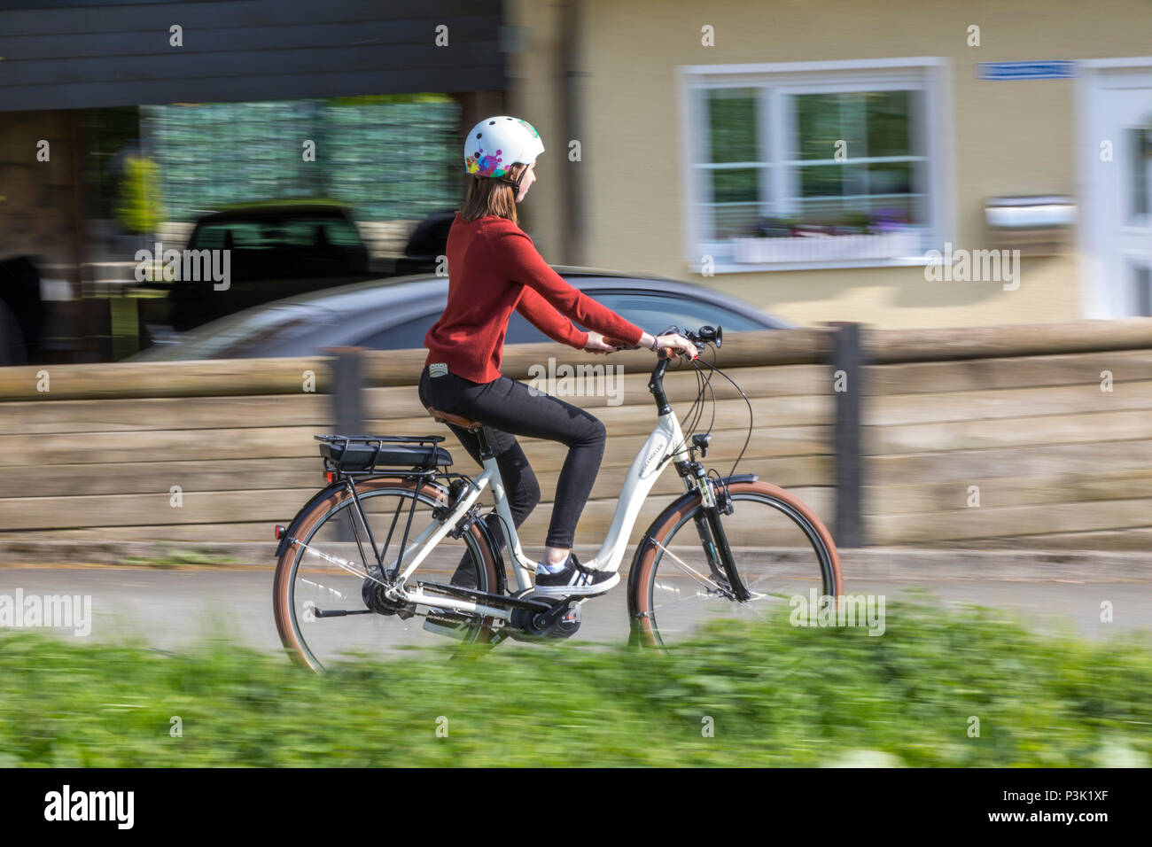 Young woman rides an e-bike, electric bike, electric motor assisted driving, Stock Photo