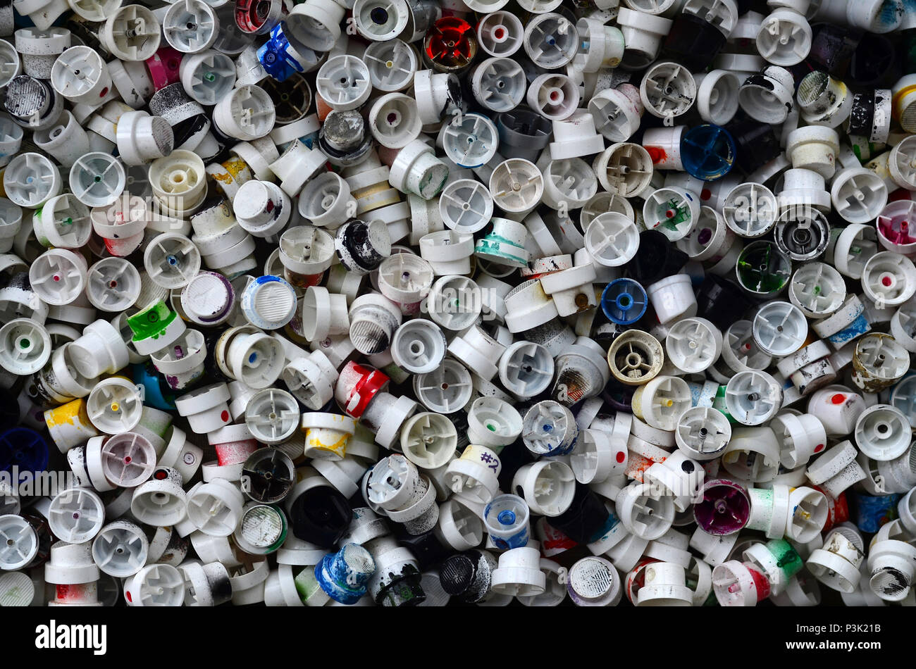 A pattern of many used and soiled nozzles from spray cans with aerosol
