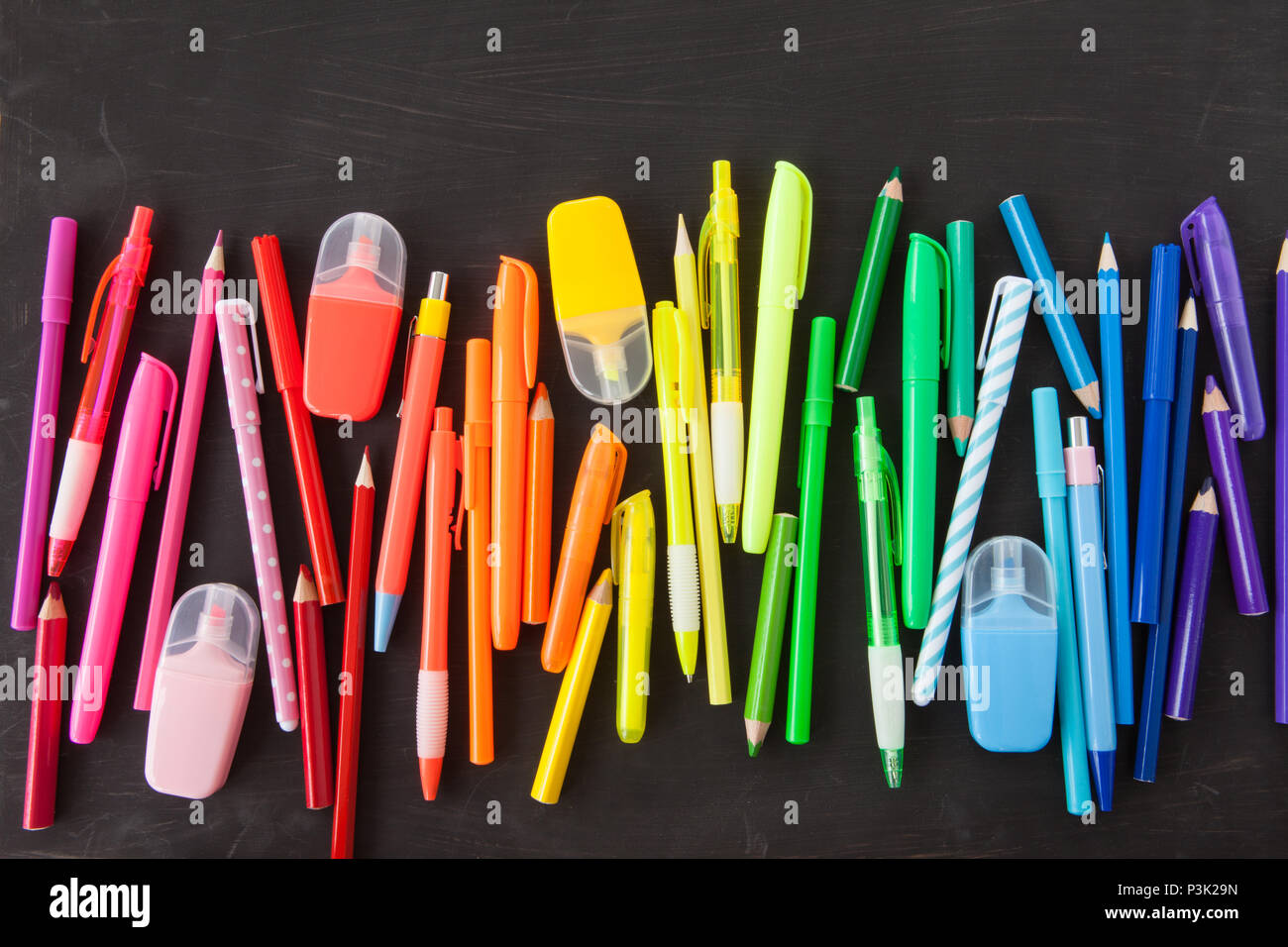 Variety of colorful pens in a rainbow on black background Stock Photo