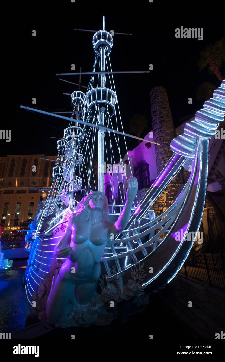 Illuminated pirate ship with statue representing a siren at Treasure Island Hotel and Casino, Las Vegas, Nevada, USA. Stock Photo