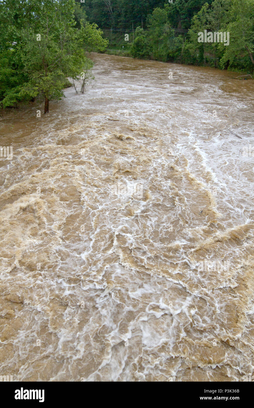 The wildly turbulent, muddy water of a flooding river after many consecutive days of rainfall Stock Photo