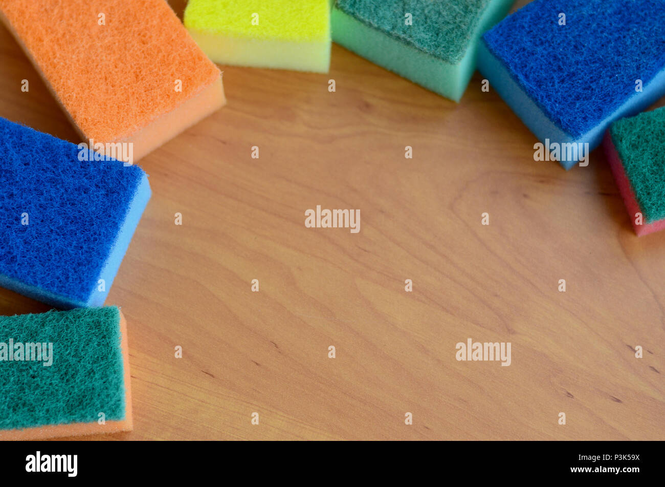 A Few Kitchen Sponges Lie On A Wooden Kitchen Countertop Colorful