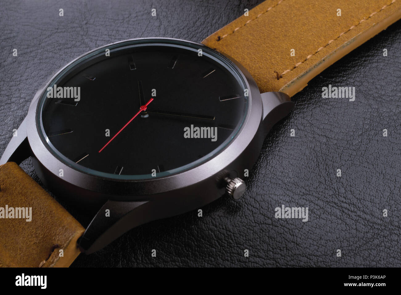 Black wrist watch with red pointer closeup macro, product shot, with leather straps and background Stock Photo