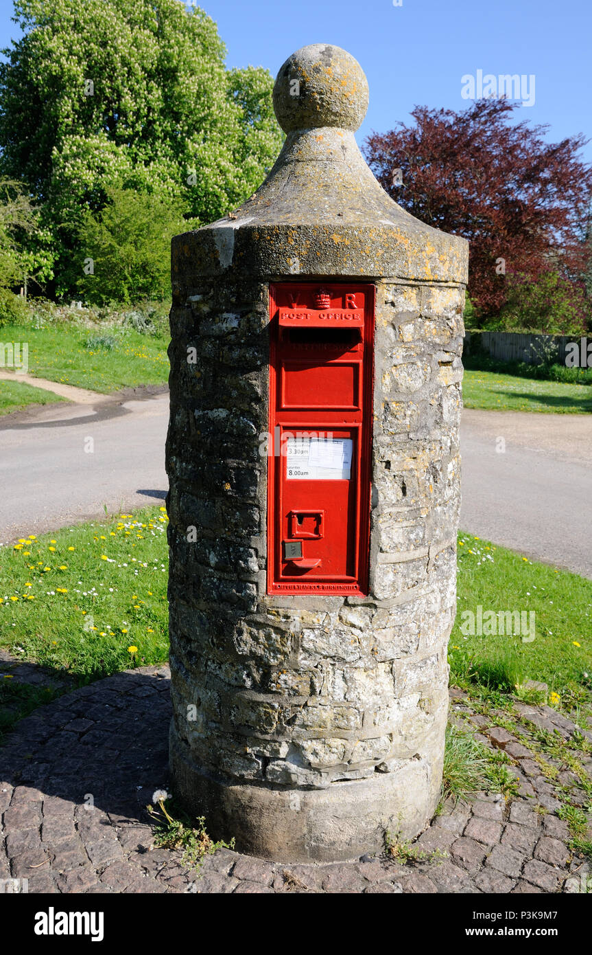 This unique Pillar Box at Nether Winchendon, Buckinghamshire, dating from 1850, stands on a circle of bricks, on a small triangular green . Stock Photo