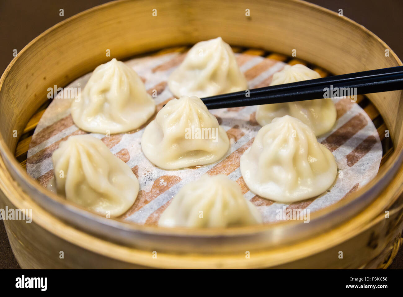 Traditional Chinese steamed dumplings in a bamboo steamer Stock Photo