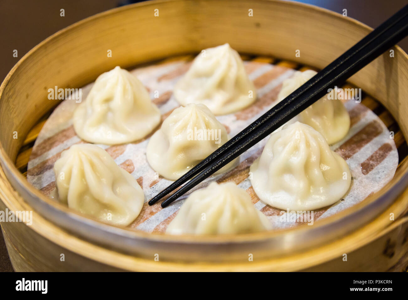 Traditional Chinese steamed dumplings in a bamboo steamer Stock Photo