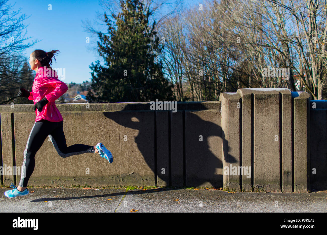 Woman jogging across bridge, Seattle, Washington, USA Stock Photo