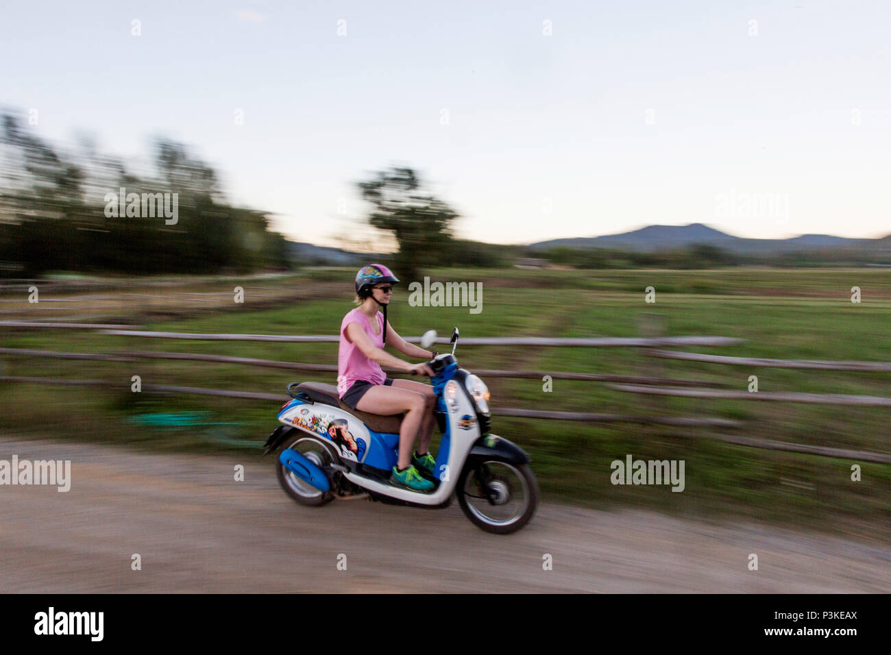 Woman riding scooter on countryside road, Pai, Mae Hong Soon, Thailand Stock Photo