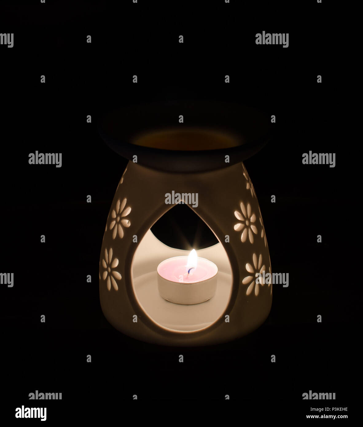 Aroma lamp in the darkness. Candle light in the darkness. Stock Photo