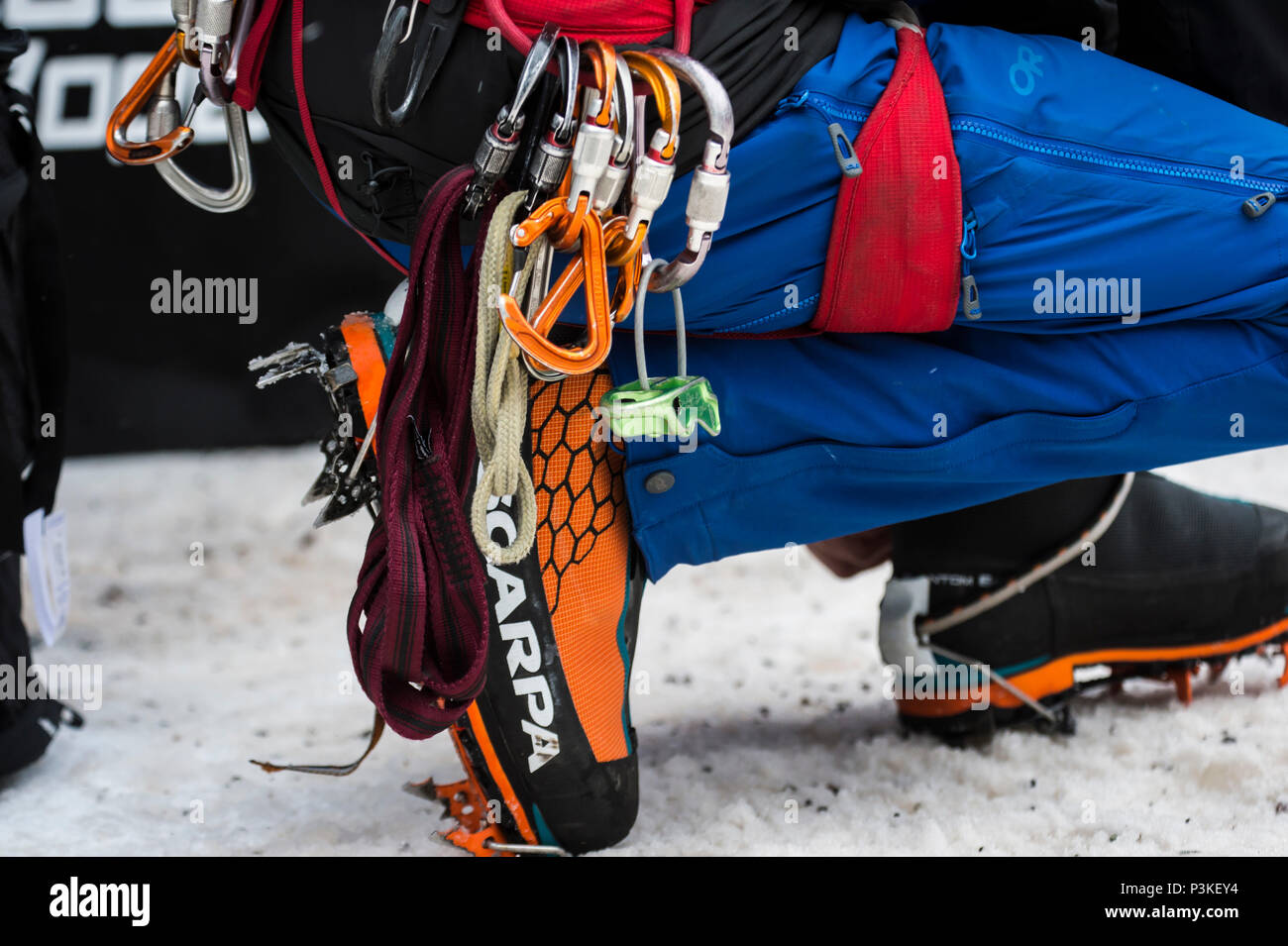 Close-up of ropes and carabiners of crouching ice climber, Colorado, USA Stock Photo