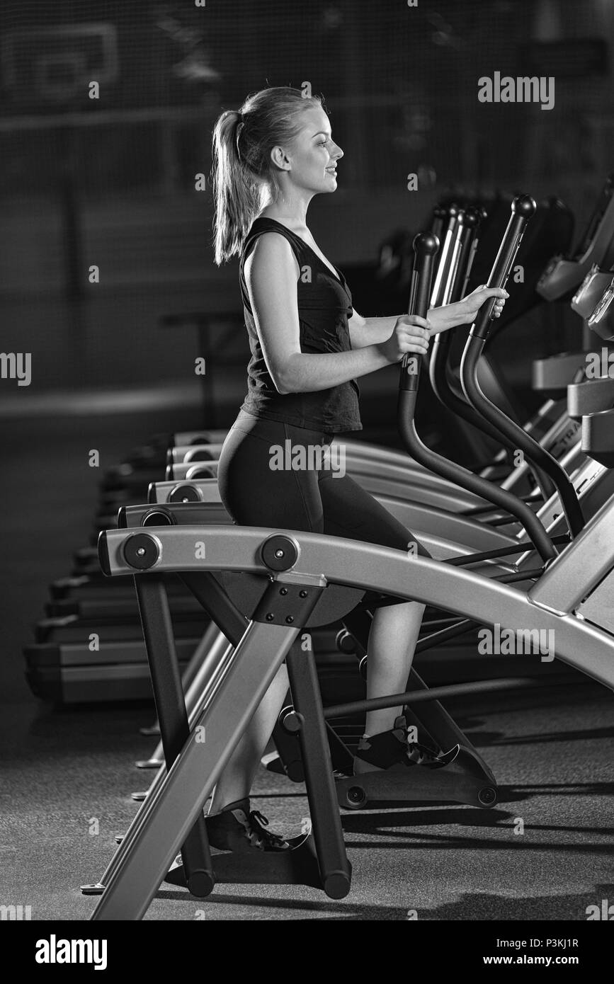 Young woman at the gym exercising. Run on on a machine. Jogging workout