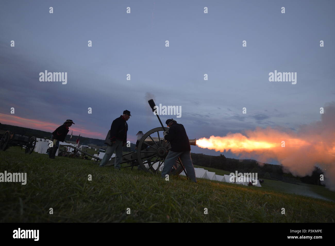 GETTYSBURG, PA - A team of United States military veterans mans and fires a Civil War-era cannon at dusk during the 153rd anniversary of the Battle of Gettysburg on July 3rd, 2016. The team, members 6th New York Light Artillery, included veterans from the Marines, Army, Navy, and Army National Guard.    The Battle of Gettysburg took place over three days, from July 1–3, 1863, in and around the town of Gettysburg, Pennsylvania. The battle was described as the turning point of the Civil Warm and involved the largest number of casualties of the conflict, ending with over 23,000 casualties on the  Stock Photo