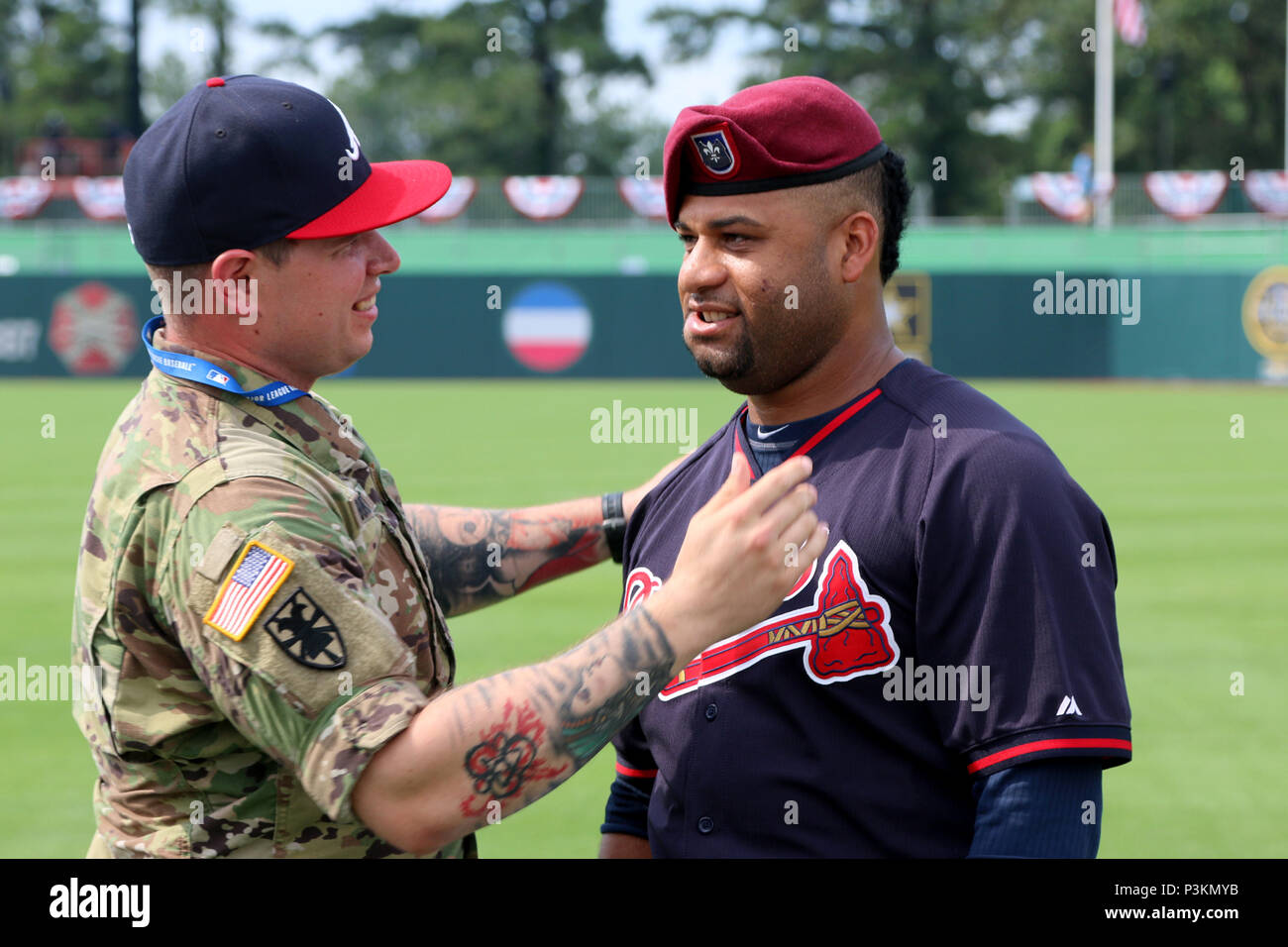 Sgt. 1st Class Alex Burnett, Public Affairs Noncommissioned Officer, 82nd  Airborne Division, ensures Atlanta Braves pitcher Arodys Vizcaino is  properly wearing a beret on Sunday, July 3, 2016, prior to the start