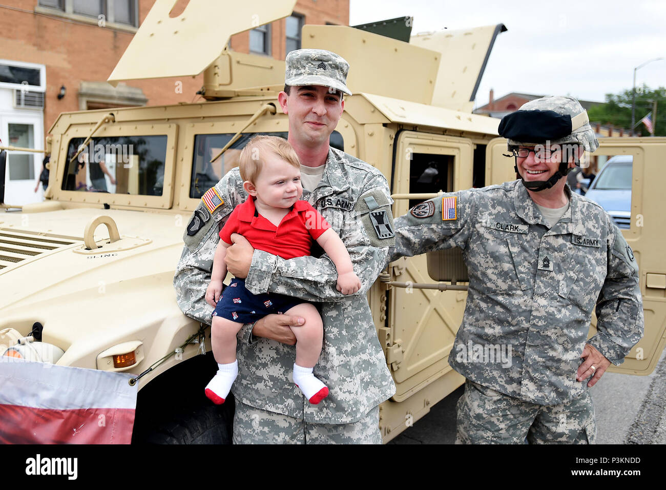 Sgt. Adam Burson, holding seven-month-old Dylan Blicharz of Melrose Park, with Master Sgt. Keith Clark, 85th Support Command stand in front of a Humvee before the Villa Park annual Fourth of July parade, July 4, 2016.  (U.S. Army photo by Spc. David Lietz/Released) Stock Photo