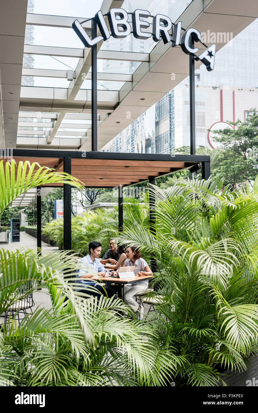 People sitting down outdoors at a modern cafeteria in Asia Stock Photo