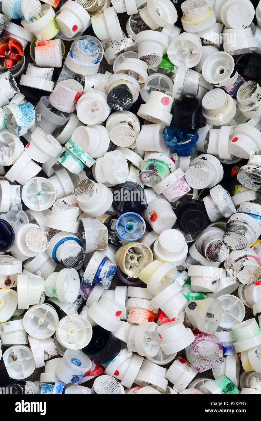 A large number of caps from cans of aerosol paint for graffiti. Smeared