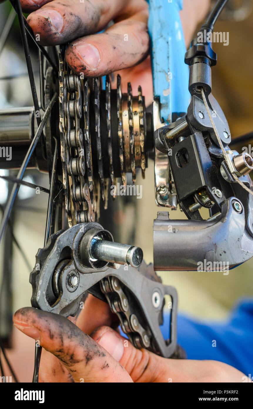 Broken Bicycle Rear Derailleur. Hands Hold the Parts of the Rear