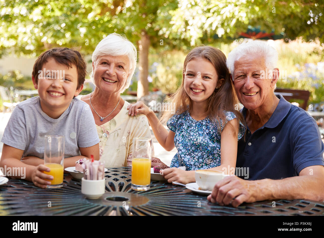 Grandparents And Grandchildren Enjoying Snack At Outdoor Café Stock 