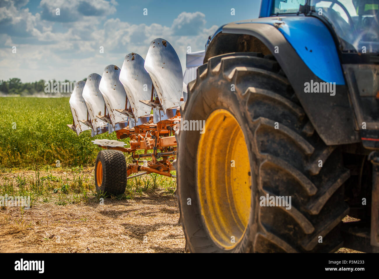 tractor with plough beside the field Stock Photo