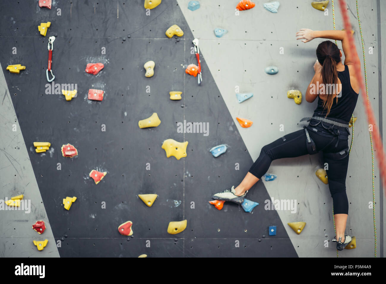 Sporty young woman training in a colorful climbing gym Stock Photo - Alamy