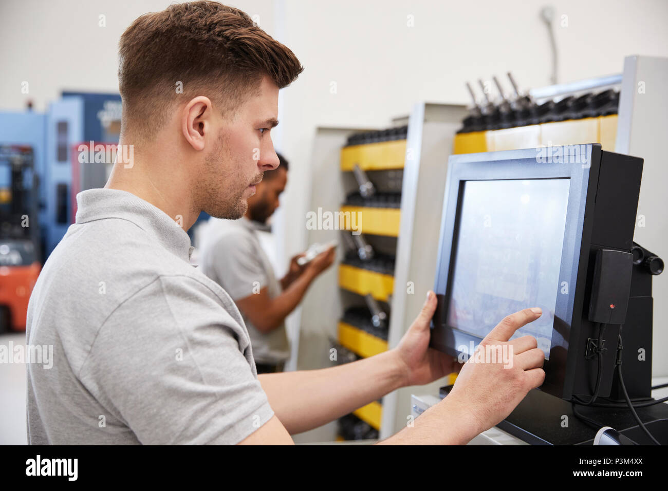 Engineers Selecting Tools For Use On Machinery In Factory Stock Photo