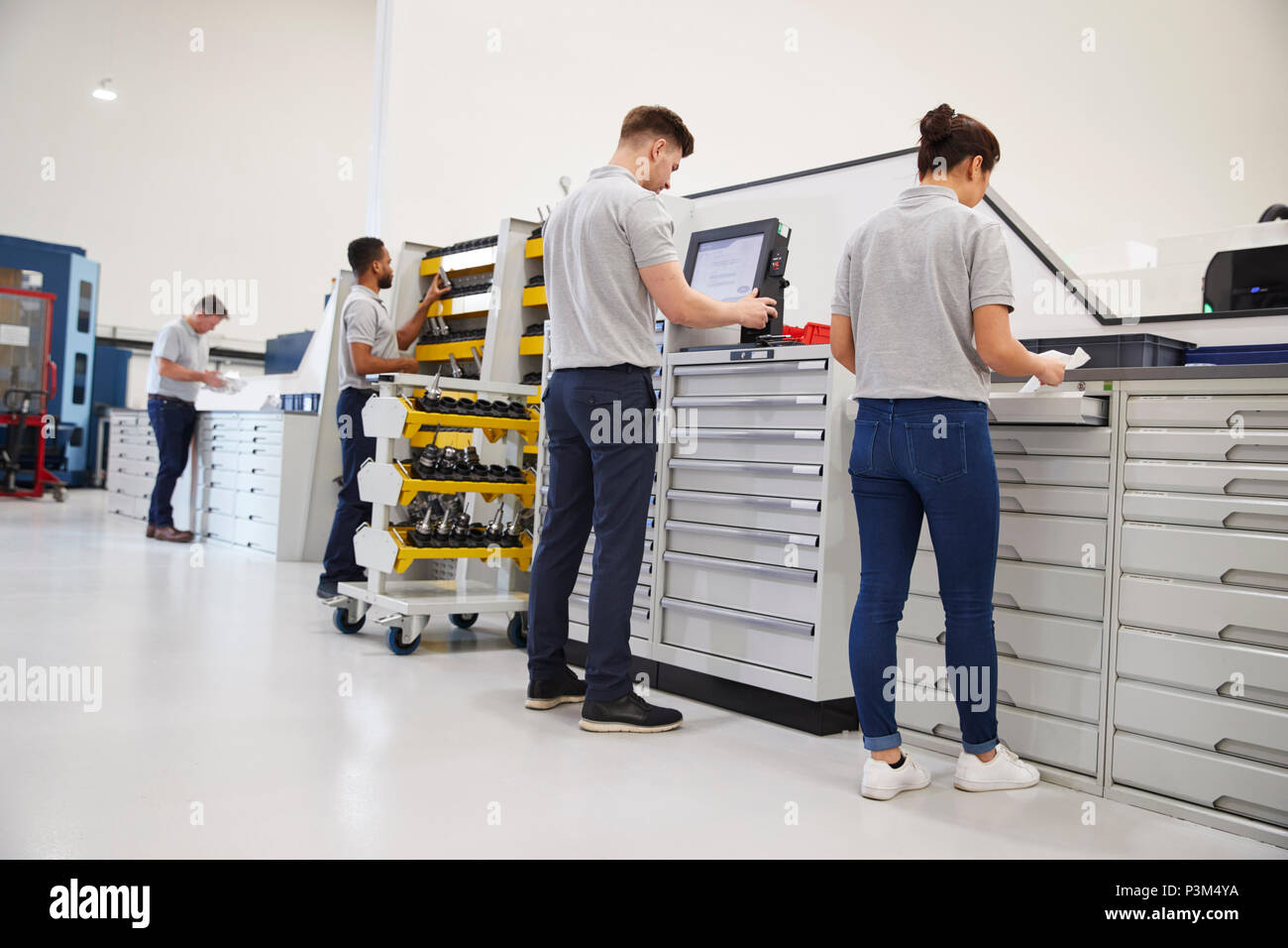 Engineers Selecting Tools For Use On Machinery In Factory Stock Photo