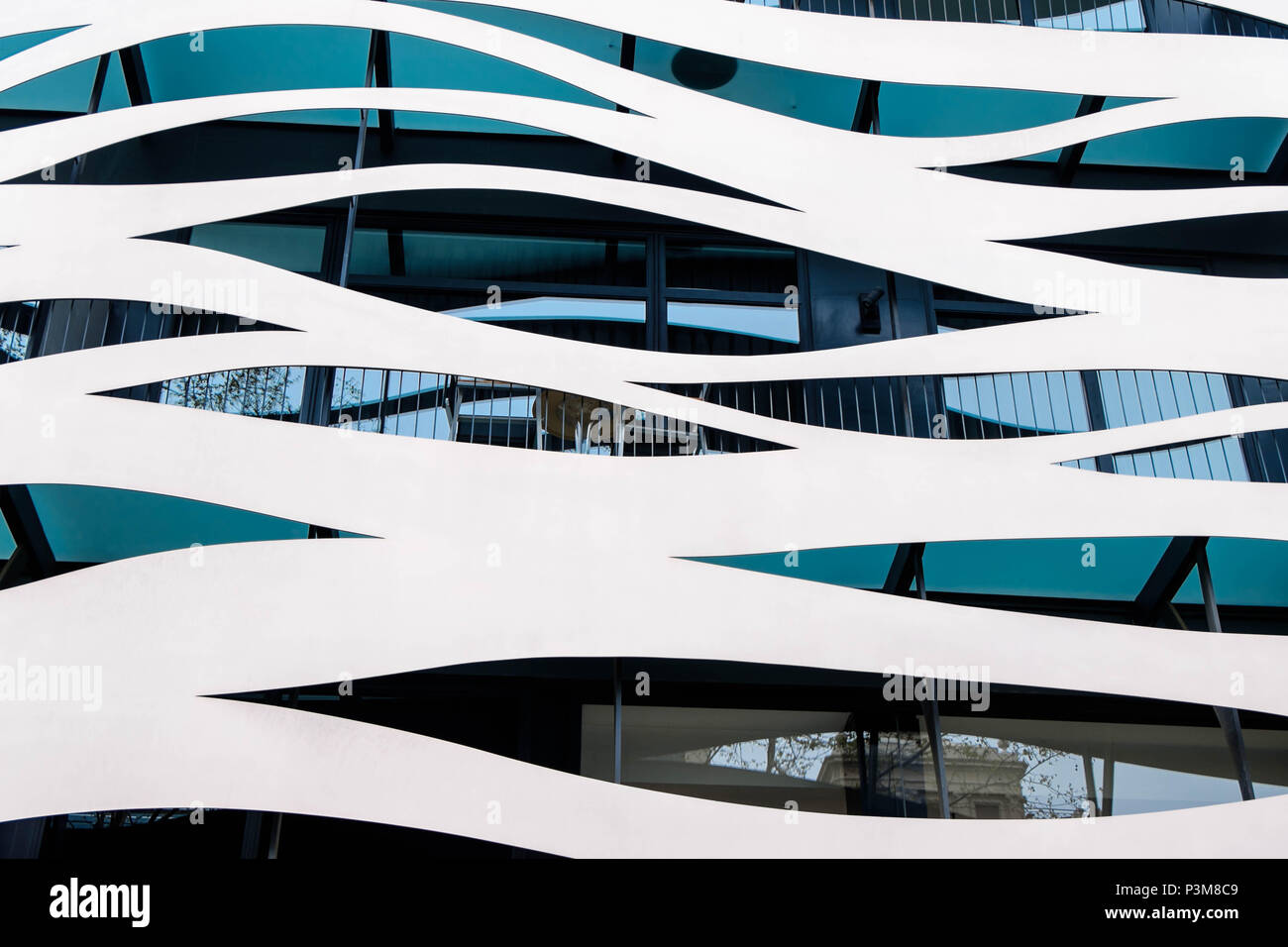 A modern facade of a building in Barcelona shows wavy structures in a white color. Stock Photo