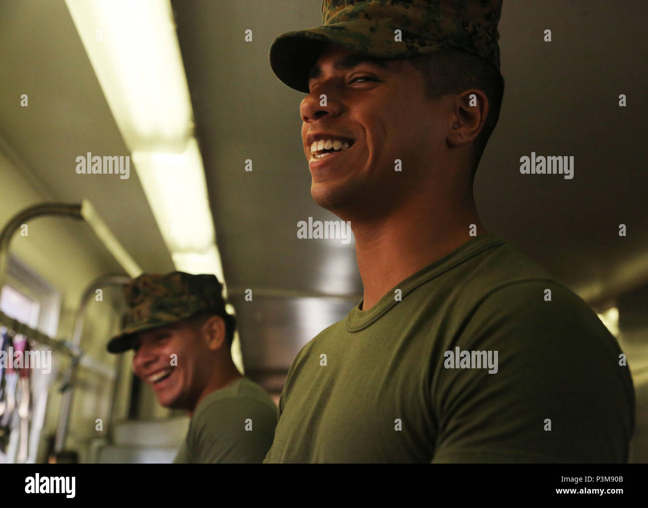 160710-N-ND246-007 POHAKULOA TRAINING AREA, Hawaii (July 10, 2016) – Lance Cpl. Teran Moises jokes with another mess hall worker in Pohakuloa Training Area, Hawaii, July 10, 2016, during Rim of the Pacific 2016. Twenty-six nations, 49 ships, six submarines, about 200 aircraft, and 25,000 personnel are participating in RIMPAC 2016 from June 29 to Aug. 4 in and around the Hawaiian Islands and Southern California. The world’s largest international maritime exercise, RIMPAC provides a unique training opportunity while fostering and sustaining cooperative relationships between participants critical Stock Photo