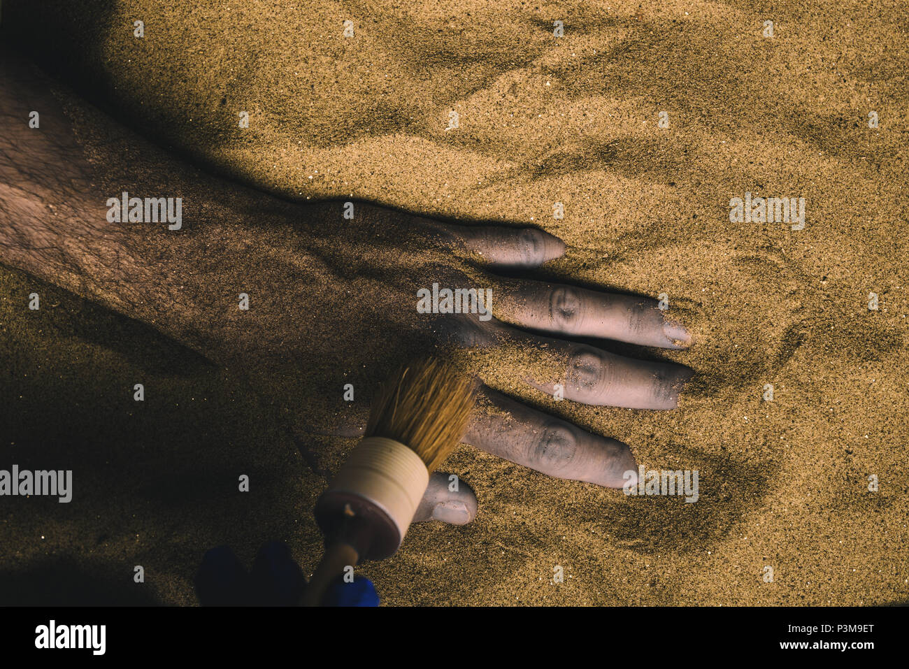 Forensic expert discovering dead body buried in desert sand. Conceptual image for police investigation of an cold case murder crime scene. Stock Photo