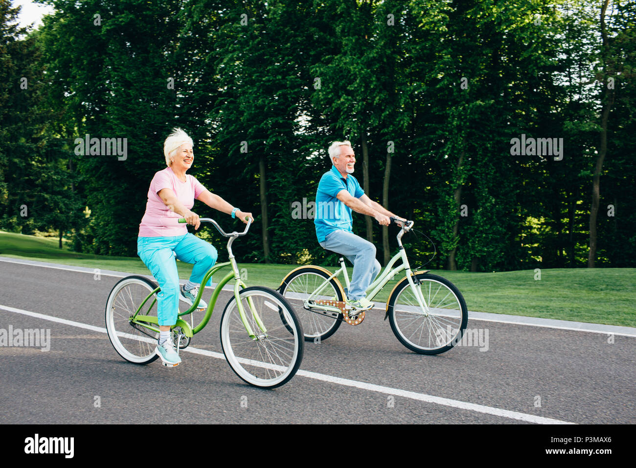 Older couple riding bicycles together Stock Photo