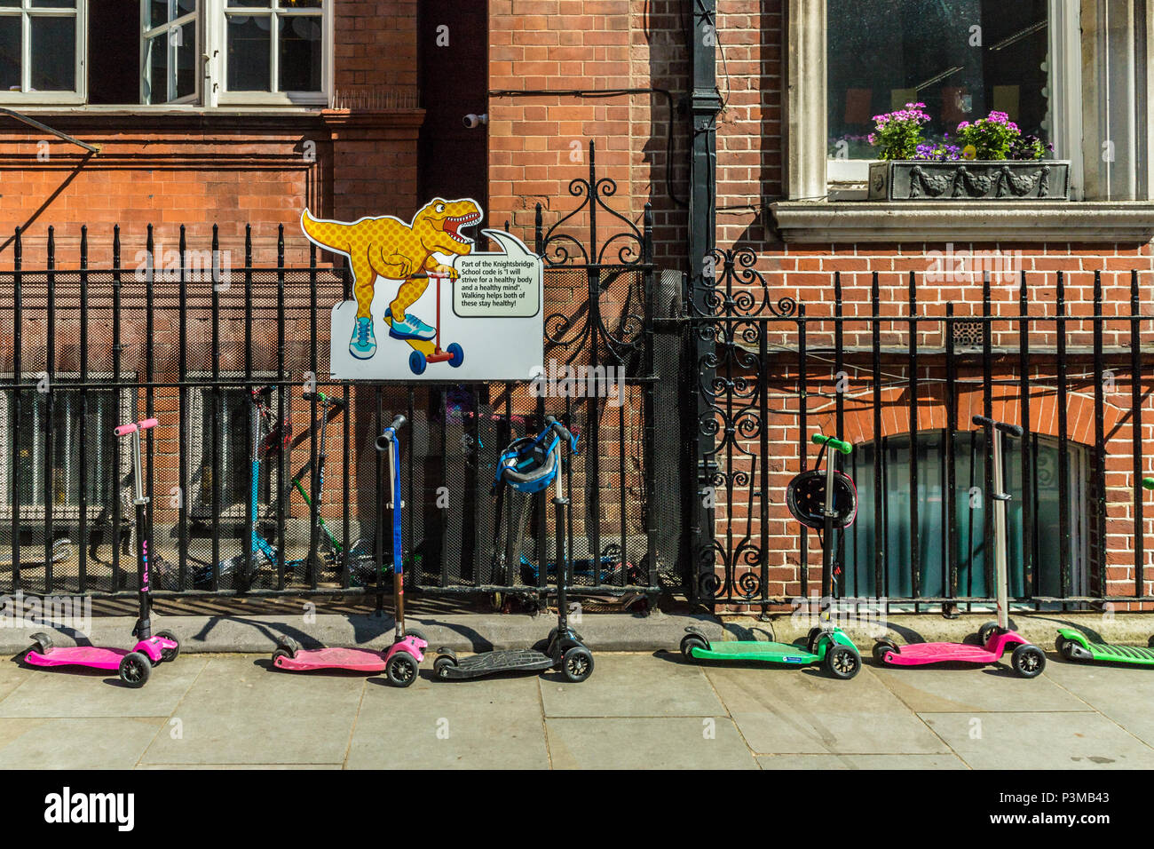 childrens scooters outside a school Stock Photo