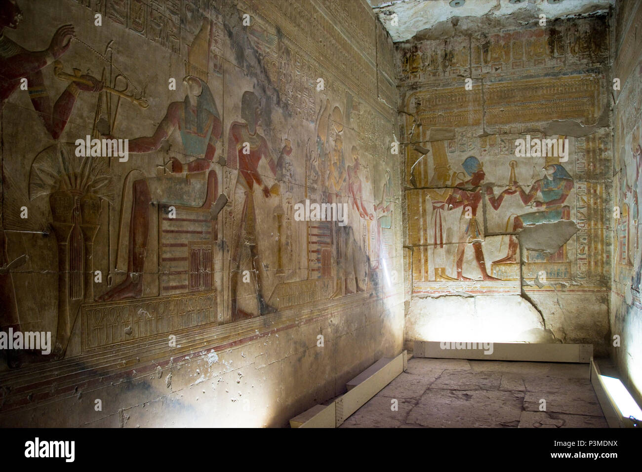 Colorfully painted bas relief carvings depict Pharaoh and the Egyptian gods inside the Great Osiris Temple built by Pepi I, Abydos, Egypt. Stock Photo