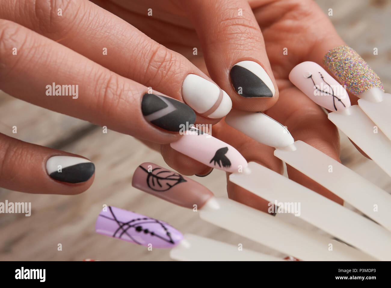 Nail art samples in female hands. Stock Photo