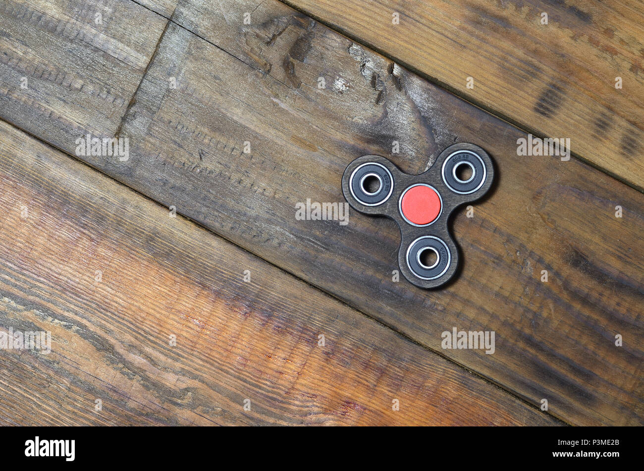 A rare handmade wooden fidget spinner lies on a brown wooden background  surface. Trendy stress relieving toy Stock Photo - Alamy