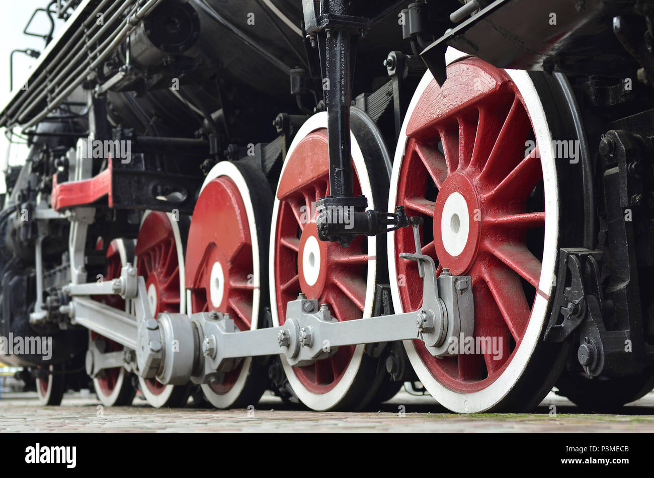 Red wheels of old USSR black steam locomotive. Wheels of an old soviet ...