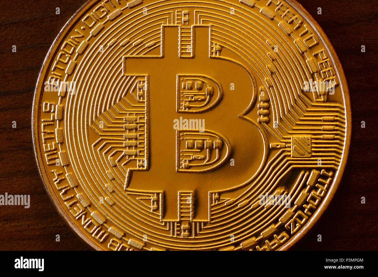 One new golden physical bitcoin is lies on dark wooden backgound, close up.  High resolution photo. Cryptocurrency mining concept Stock Photo - Alamy