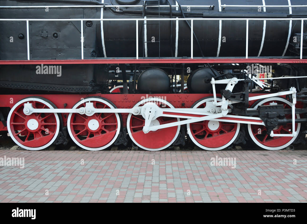 Wheels of the old black steam locomotive of Soviet times. The side of ...