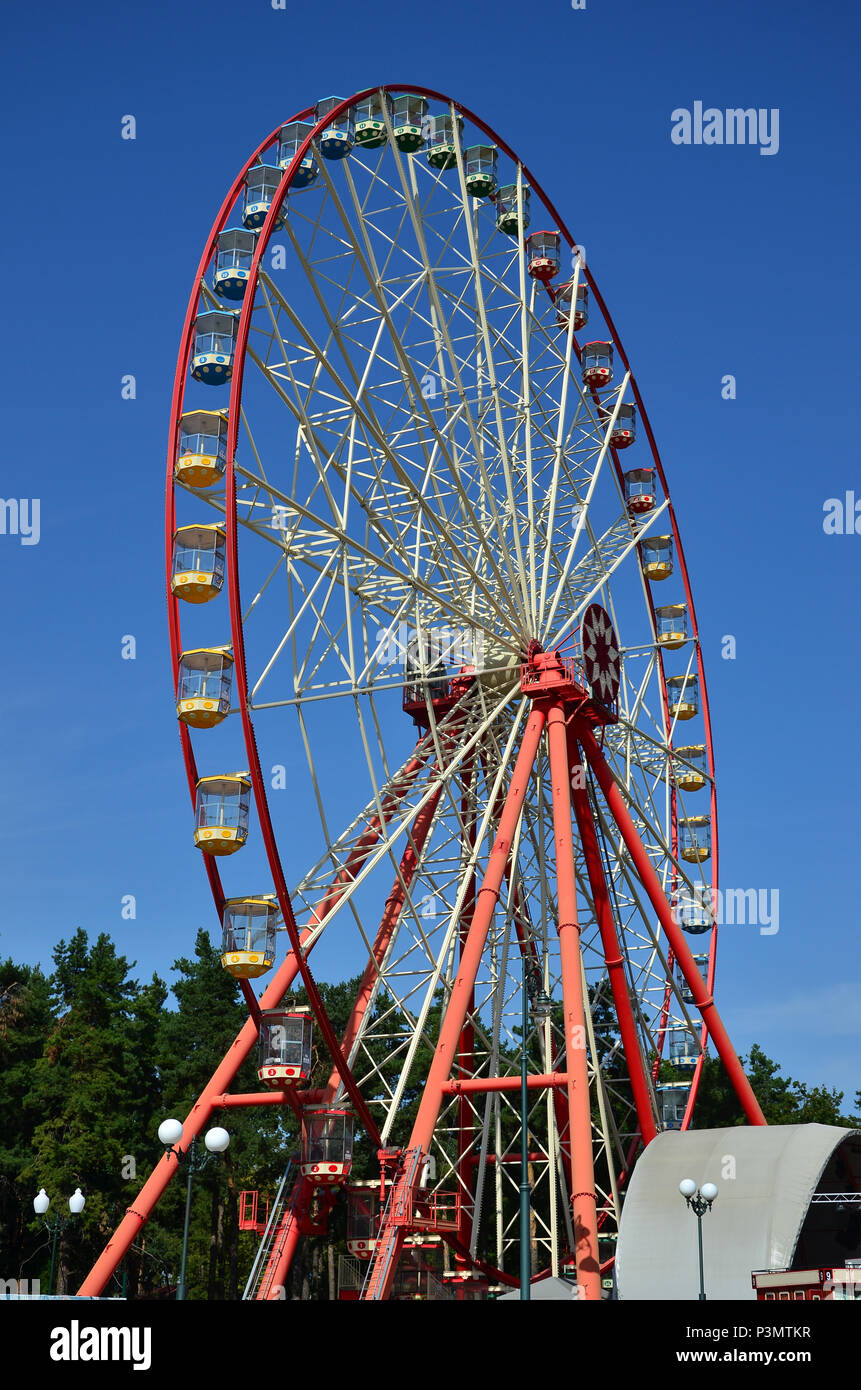 Big and modern multicolour ferris wheel on clean blue sky background ...