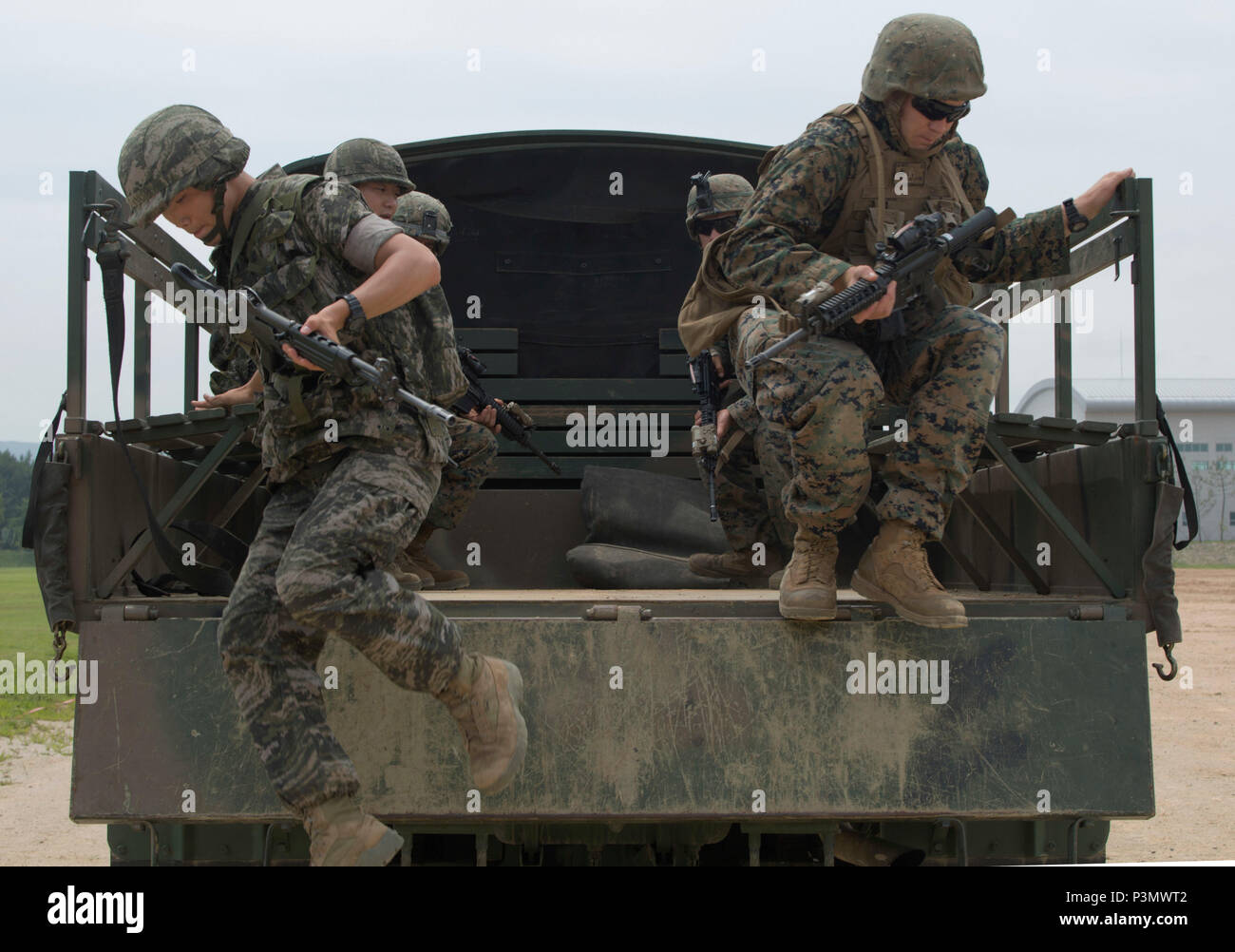 A Republic of Korea Marine and a U.S. Marine jump from the back of a truck during convoy escort training July 11, 2016 during Korean Marine Exchange Program 16-11. KMEP offers realistic training leveraging the most advanced tactics and technology to ensure a trained and ready ROK-U.S. combined force. The ROK Marines are with 73rd Battalion, 7th Regiment, 1st Marine Division. The U.S. Marines participating in this training event are with 2nd Battalion, 2nd Marine Regiment, currently assigned to 4th Marine Regiment, 3rd Marine Division, III Marine Expeditionary Force through the unit deployment  Stock Photo