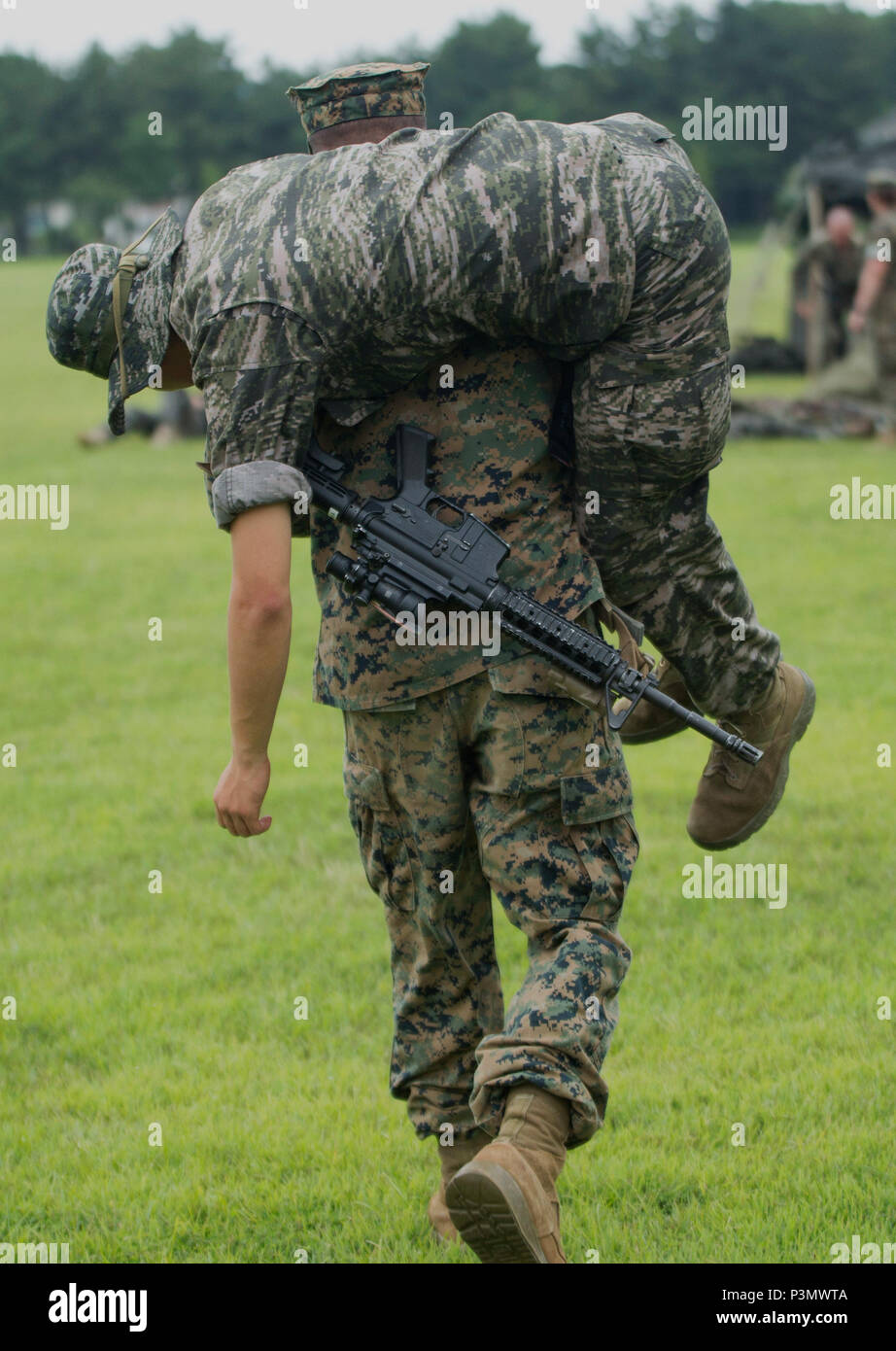 A U.S. Marine fireman-carries a Republic of Korea Marine during a first aid during combat training operation July 11, 2016 during Korean Marine Exchange Program 16-11. KMEP offers realistic training leveraging the most advanced tactics and technology to ensure a trained and ready ROK-U.S. combined force. The ROK Marines were a part of 73rd Battalion, 7th Regiment, 1st Marine Division. The U.S. Marines participating in this training event were a part of 2nd Battalion, 2nd Marine Regiment, currently assigned to 4th Marine Regiment, 3rd Marine Division, III Marine Expeditionary Force through the  Stock Photo