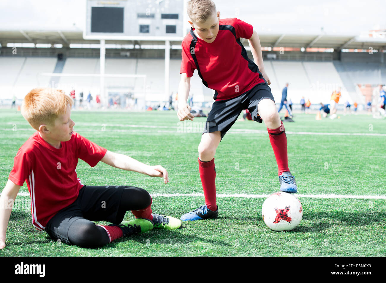 Children Playing Football in Stadium Stock Photo