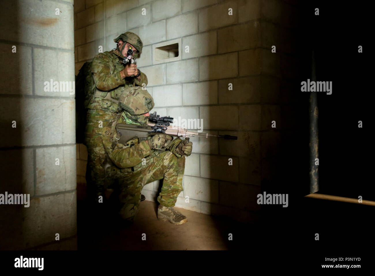 160713-M-JM737-009 KAHUKU TRAINING AREA, Hawaii (July 13, 2016) - Members of an Australian Army fireteam, attached to Golf Company, 2nd Battalion, 3rd Marines, prepare to breach a door to secure an objective during Rim of the Pacific 2016. Twenty-six nations, 49 ships, six submarines, about 200 aircraft, and 25,000 personnel are participating in RIMPAC 16 from June 29 to Aug. 4 in and around the Hawaiian Islands and Southern California. The world’s largest international maritime exercise, RIMPAC provides a unique training opportunity while fostering and sustaining cooperative relationships bet Stock Photo