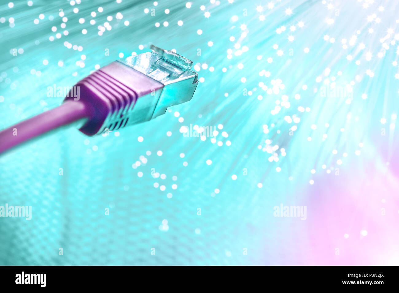 Futuristic technological background, closeup on the end of pink optical fiber network cable on turquoise background Stock Photo