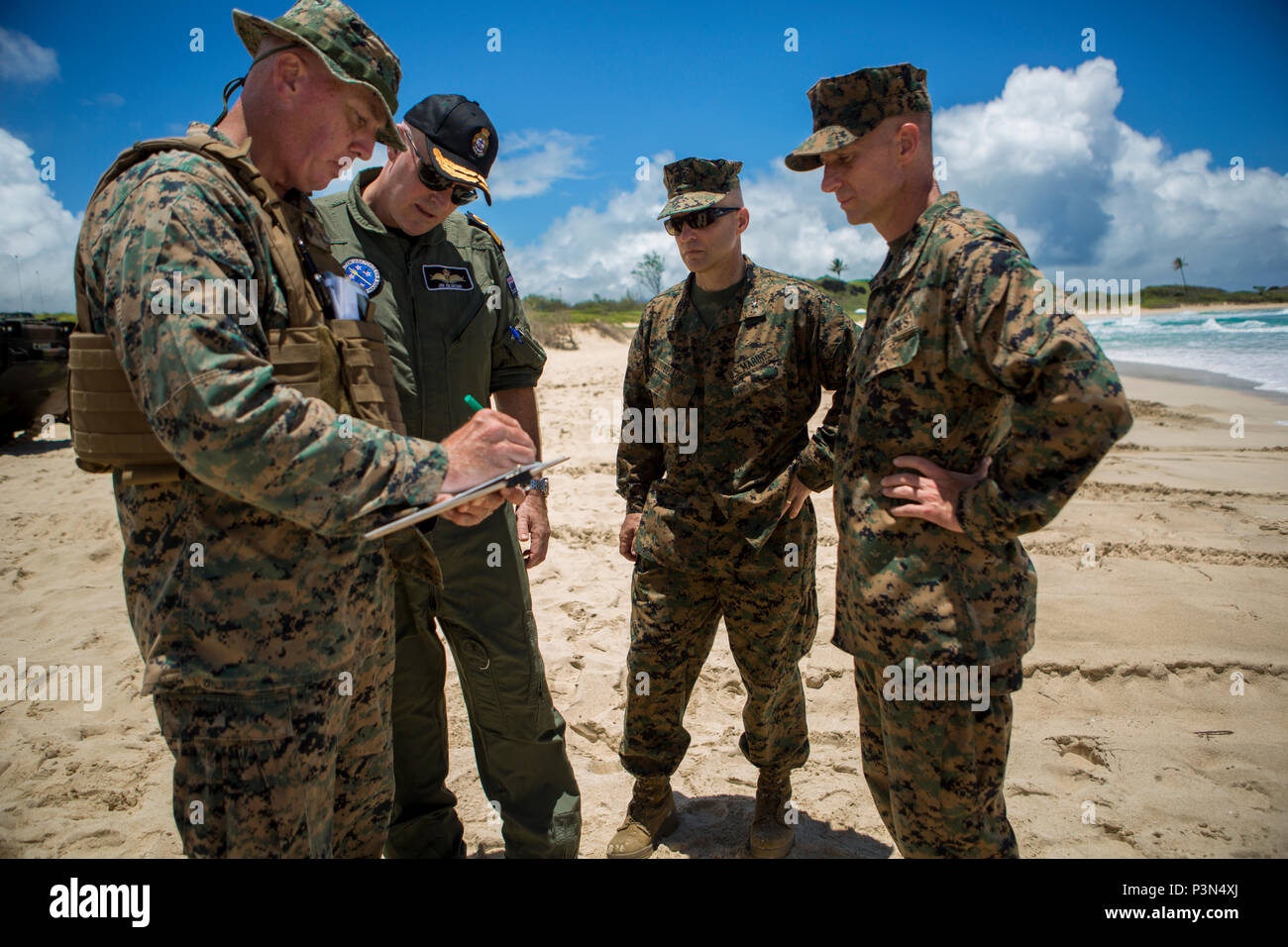 160714-M-JM737-007 MARINE CORPS BASE HAWAII (July 14, 2016) - U.S .Marine Staff Sgt. Kyle Nicholson briefs Brig. Gen. David Bellon, Royal New Zealand Navy Commodore Jim Gilmour and Col. Carl Cooper on the data he collected as Assault Amphibious Vehicles with Combat Assault Company, 3rd Marine Regiment came to shore during Rim of the Pacific 2016. Bellon is the Fleet Marine Officer, Amphibious Force; Gilmour is the Combined Forces Amphibious Component Commander; Cooper is the Commanding Officer, Provisional Marine Expeditionary Brigade Hawaii. Twenty-six nations, 49 ships, six submarines, about Stock Photo