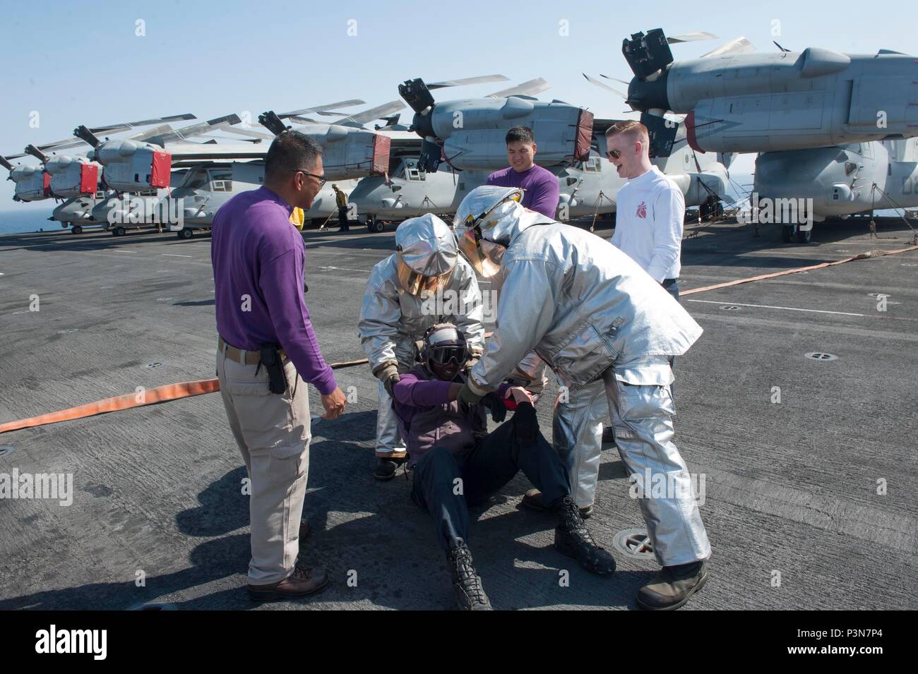 Sailors from the crash and salvage division evacuate a simulated ...