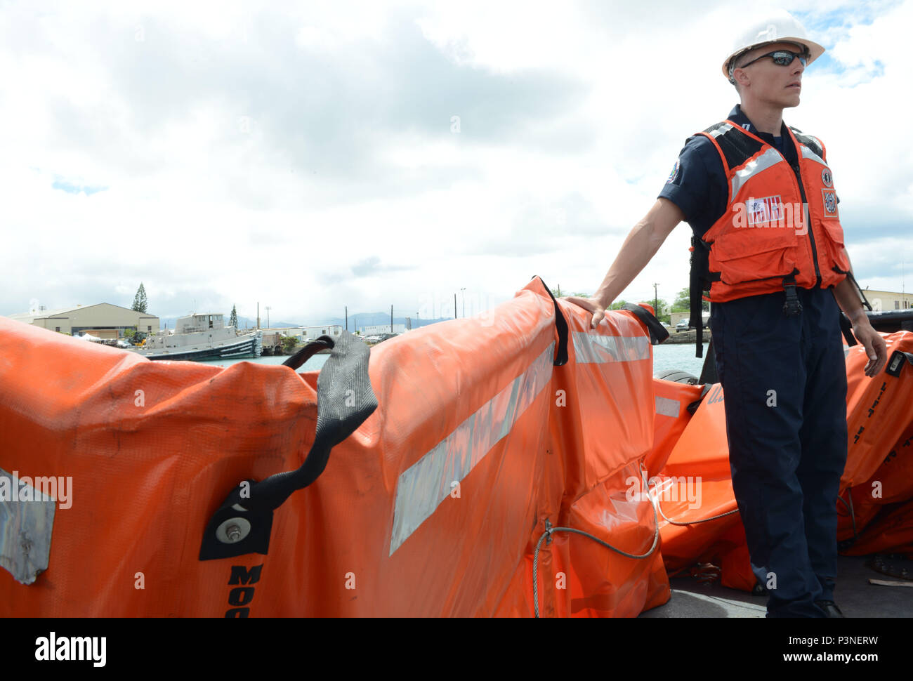 160713-G-XD768-006 JOINT BASE PEARL HARBOR-HICKAM (July 13, 2016) Lt. Tim Jones from the Coast Guard 14th District Response Advisory Team prepares to deploy boom during a training evolution to assemble, deploy and operate a Vessel of Opportunity Skimming System aboard the Tug Noha Loa during Rim of the Pacific Exercise 2016. The VOSS is a portable side-skimming oil-recovery system, which can be deployed from most work vessels over 65 feet in length. Twenty-six nations, 49 ships, six submarines, about 200 aircraft, and 25-000 personnel are participating in RIMPAC from June 29 to Aug. 4 in and a Stock Photo