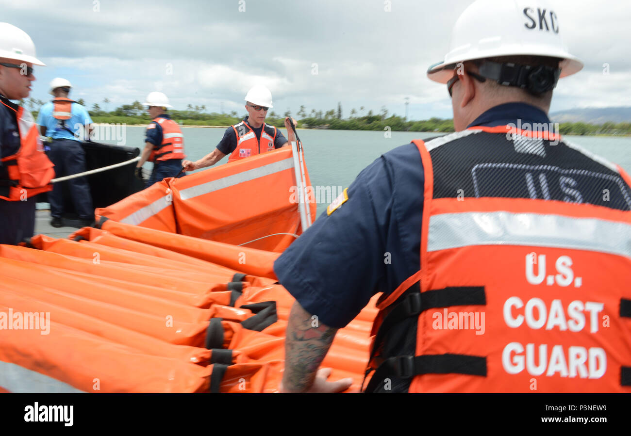 160713-G-XD768-003 JOINT BASE PEARL HARBOR-HICKAM (July 13, 2016) Crewmembers from the Coast Guard 14th District Response Advisory Team and the Coast Guard National Strike Force prepare to deploy boom during a training evolution to assemble, deploy and operate a Vessel of Opportunity Skimming System aboard the Tug Noha Loa during Rim of the Pacific Exercise 2016. The VOSS is a portable side-skimming oil-recovery system, which can be deployed from most work vessels over 65 feet in length. Twenty-six nations, 49 ships, six submarines, about 200 aircraft, and 25-000 personnel are participating in Stock Photo