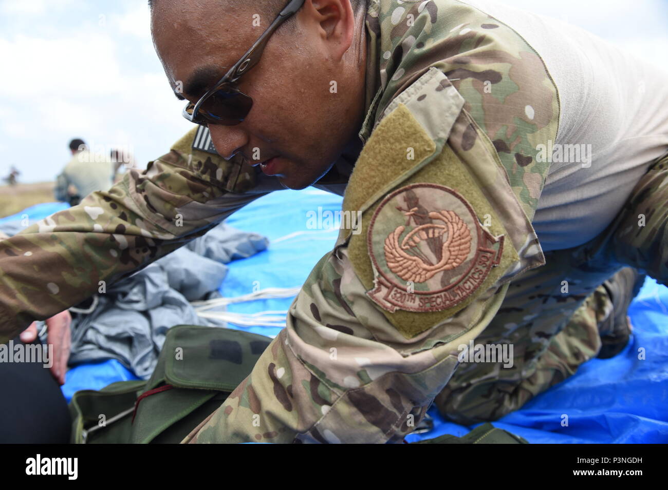 A parachute rigger with the 320th Special Tactics Squadron re-packs a parachute after a multi-aircraft, joint airborne operation with special operations assets and conventional forces from all four branches of the U.S. Armed Forces as part of Rim of the Pacific 2016 to strengthen their relationships and interoperability with their partners, Pohakuloa Training Area, Hawaii, July 14, 2016. Twenty-six nations, more than 40 ships and submarines, more than 200 aircraft and 25,000 personnel are participating in RIMPAC from June 30 to Aug. 4, in and around the Hawaiian Islands and Southern California Stock Photo