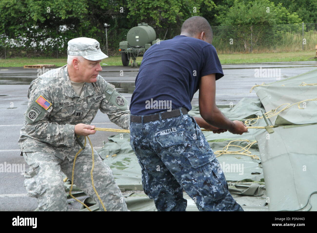 Service members from both the Army and the Navy help to set up tents for veterinary services during Healthy Cortland July 14, 2016. Healthy Cortland is one of the Innovative Readiness Training missions which provides real-world training in a joint civil-military environment while delivering world-class medical care to the people of Cortland, N.Y., from July 15-24. Stock Photo